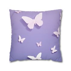 a purple pillow with white butterflies on the front and back, against a light purple background