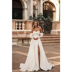 a woman in a white wedding dress posing for the camera