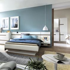 a bedroom with blue walls and white furniture