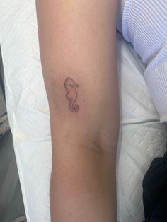 a woman's arm with a small tattoo on the left side of her arm