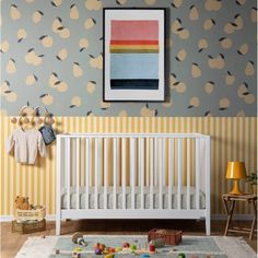 a baby's room with a white crib and yellow striped wallpaper on the walls