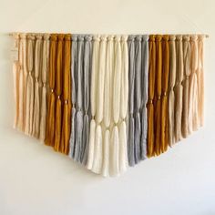 a wall hanging made out of different colored yarns