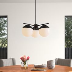 a dining room table with two lights hanging over it