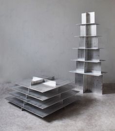 a stack of metal boxes sitting on top of a floor next to a wall with no one in it