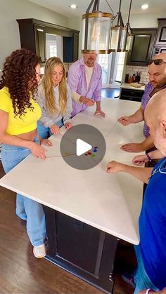 a group of people standing around a kitchen table