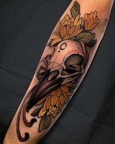 a skull and flowers tattoo on the arm