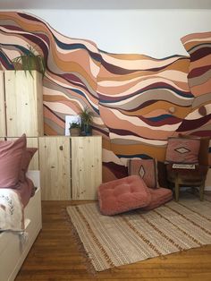 a living room filled with furniture and colorful wallpaper on the walls, along with a rug