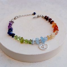 Our Chakra bracelet is made with 7 chakra gemstones and each natural gemstone is separated with silver seed beads to fit comfortably around the wrist. The bracelet is finished with a Sterling Silver Ohm charm. Each item in our collection, is designed and handmade by Fran in our sunny Suffolk studio.   Closure - Surgical stainless steel lobster clasp and adjustable loop fastening, with extension chain 7" - 8", that is strong, hypoallergenic and waterproof. Chakra Stones and Meaning Garnet - Root Chakra Bracelet Diy Ideas, Chakras Bracelet, Chakra Gemstones, Bracelet Chakra, Chakra Racine, Meditation Jewelry, 7 Chakra, Yoga Gifts, Chakra Bracelet