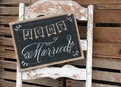 an old white chair with a chalkboard sign hanging from it's back side