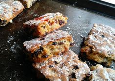 several pastries sitting on top of a pan covered in powdered sugar