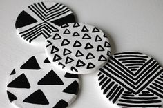 three black and white patterned coasters sitting on top of a table