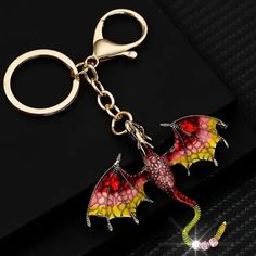 a red and yellow dragon shaped keychain sitting on top of a black surface