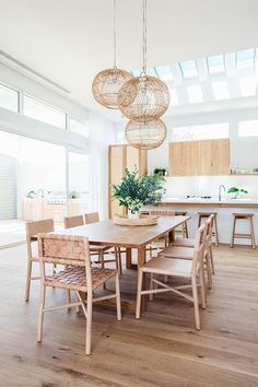 a dining room table with chairs and lights hanging from the ceiling