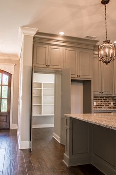 an image of a kitchen with white cabinets and wood flooring on the phone screen