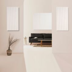 a living room with a black couch and two mirrors on the wall next to it