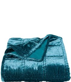 a blue blanket is folded on top of a bed