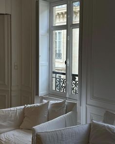 a white couch sitting in front of a window