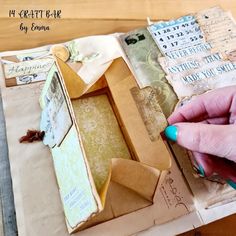 a person is making a box out of old papers and other paper maching materials