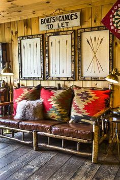 a living room filled with lots of furniture and pillows on top of wooden flooring