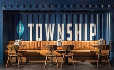 a group of wooden chairs sitting next to each other in front of a blue wall