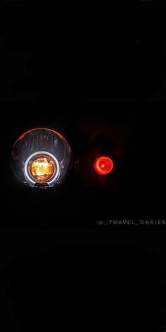 the tail light of a car in the dark with its lights turned red and yellow