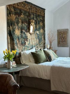 a large tapestry hanging over a bed in a bedroom