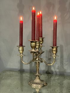 four candles are lit on a silver table