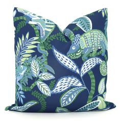 a blue pillow with green and white leaves on the front, along with a dark blue background