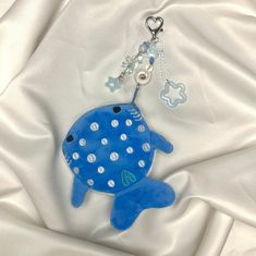 a blue fish keychain with white dots on it's body and chain