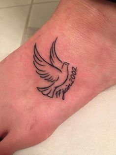 a small tattoo on the foot of a person's foot with a bird flying above it