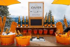 an outdoor bar with orange buckets and yellow umbrellas on it's side