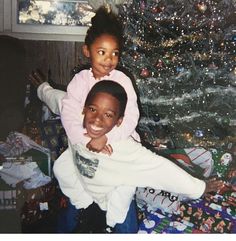 two children sitting in front of a christmas tree