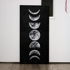 three phases of the moon are shown in this black and white painting on a wall