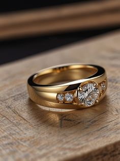 two gold wedding rings with diamond accents on top of a wooden table next to each other