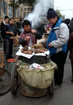 two men are cooking food on an outdoor grill