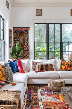 a living room filled with lots of furniture and pillows on top of a white couch