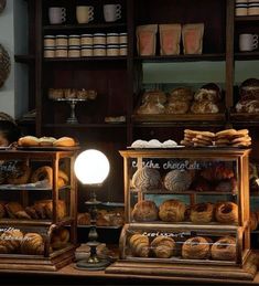 there are many breads on display in the bakery shop and one has a lamp