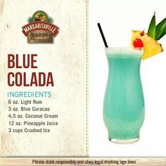 a blue cocktail with pineapple on the top and in a tall glass next to a sign that says blue collada ingredients