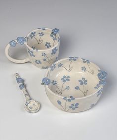 two bowls and spoons with blue flowers on them