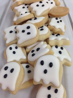 cookies decorated with white icing and black polka dots in the shape of ghost heads