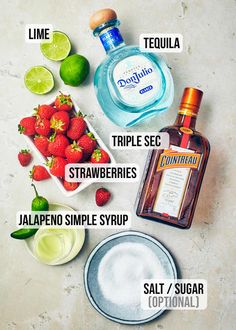 the ingredients to make strawberry margarita cocktail are shown in this image, including strawberries, limes, salt, and tequila