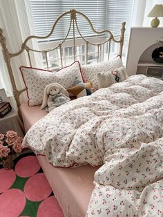 a bed with white and pink comforters in a bedroom