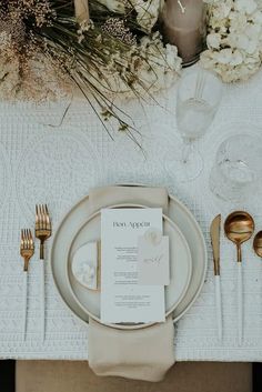 a place setting with silverware, napkins and flowers