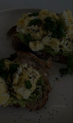 two pieces of toast with eggs and spinach on them sitting on a white plate