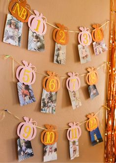 an orange and pink birthday banner hanging from a string with pictures on it, including pumpkins