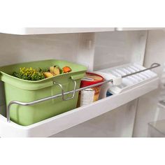 a green container with food in it sitting on top of a shelf