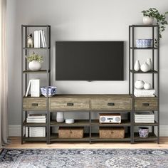 a living room with a large television on the wall and some bookshelves in front of it