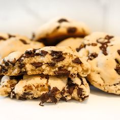 chocolate chip cookies stacked on top of each other with one broken cookie in the middle