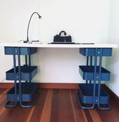 two blue plastic bins sitting on top of a white counter next to a lamp