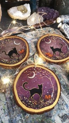 three decorated cookies sitting on top of a table next to other items and decorations with lights